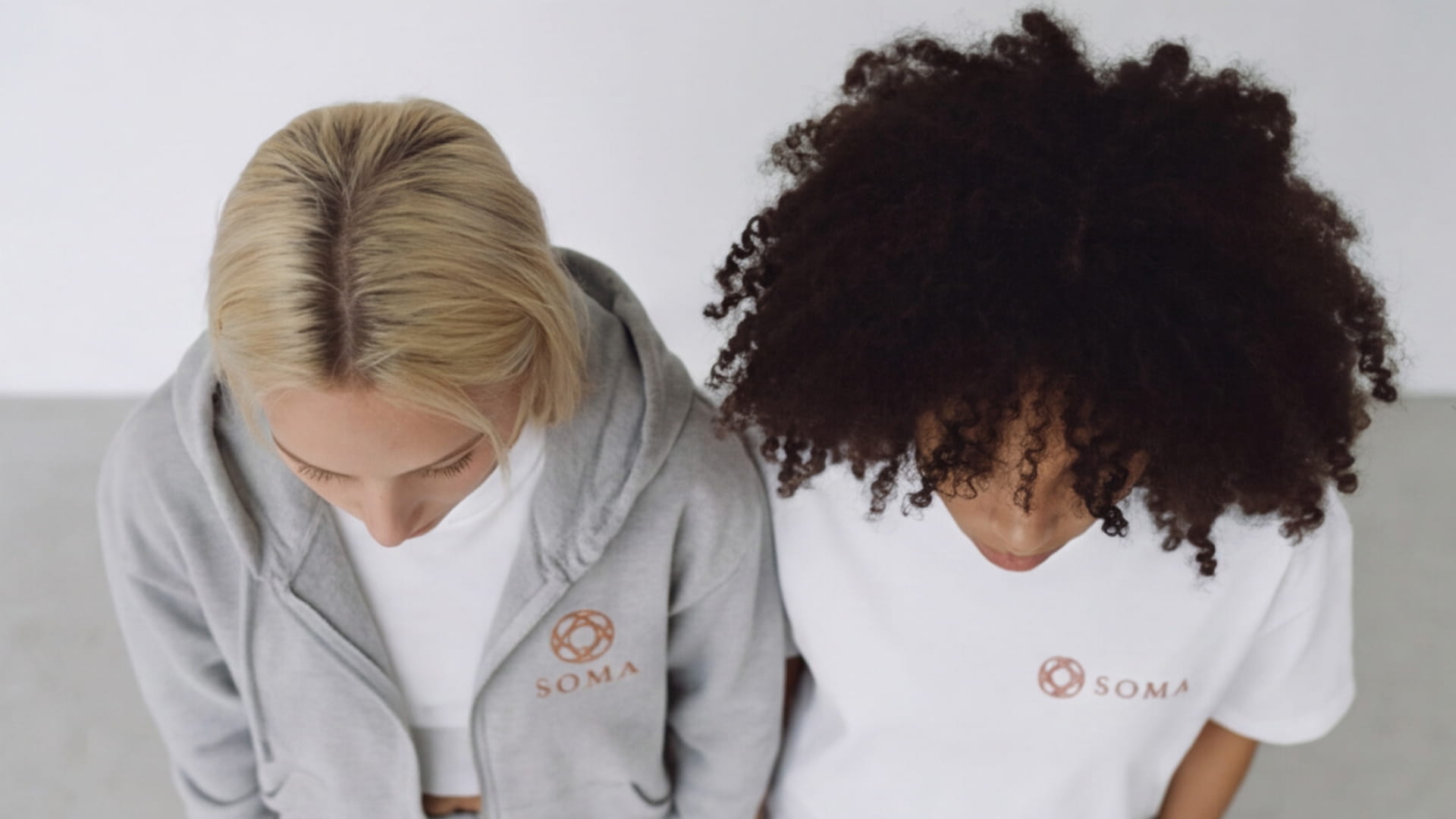 Prendas blancas y grises con el logotipo de SOMA.
